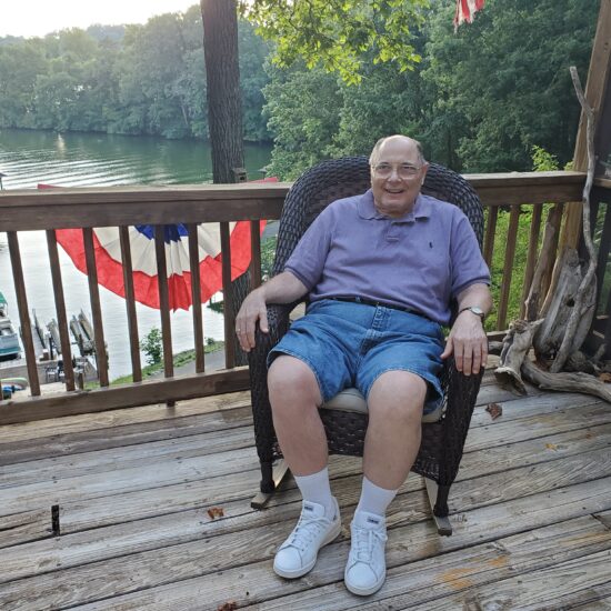 Gabriel Homes resident sitting on a balcony overseeing a lake.