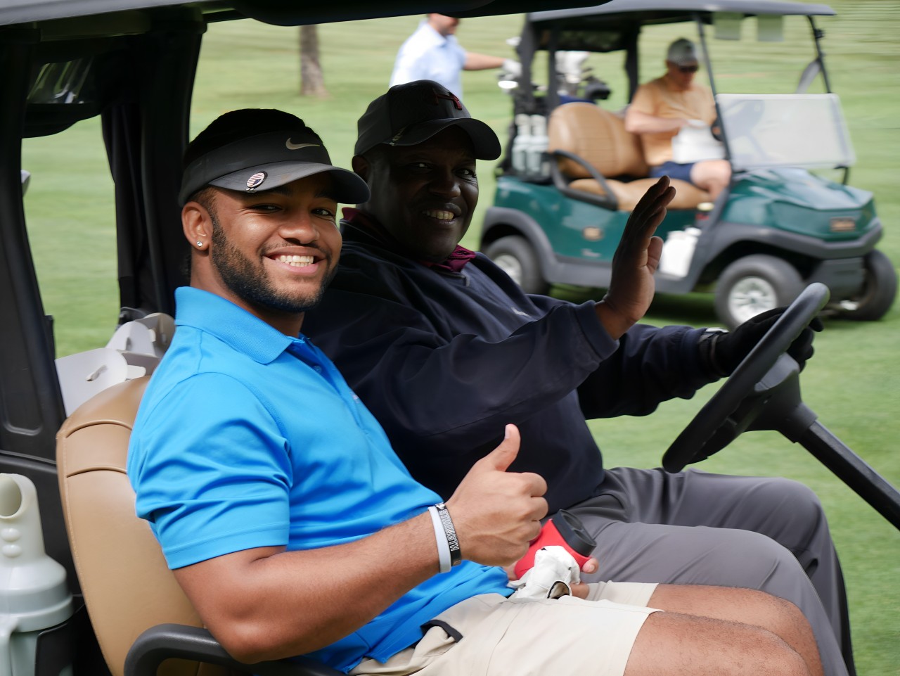 Golfers at 29th annual Gabriel Homes golf tournament riding in golf cart.