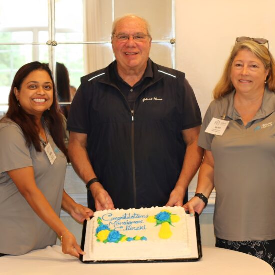 Monsignor Bob Cilinski (center) with cake at Gabriel Homes Golf Tournament.