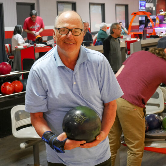 Gabriel Homes resident holding bowling ball. The sport boosts physical and mental health.