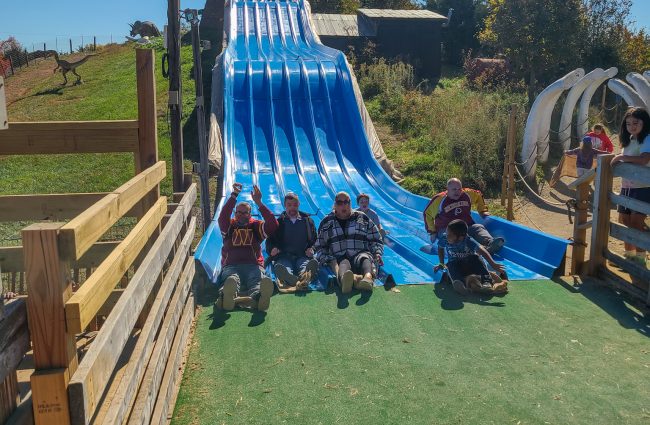 Gabriel Homes residents at Cox Farms going down the Dino Slide.