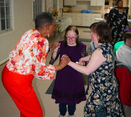 Marlene (left), residential counselor at Gabriel Homes, dancing with two residents (center and right).