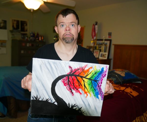 Gabriel Homes resident holding a canvas they painted.