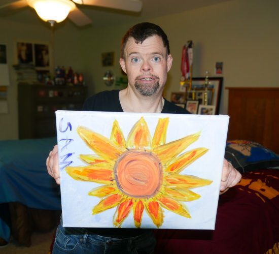 Gabriel Homes resident holding a canvas they painted.